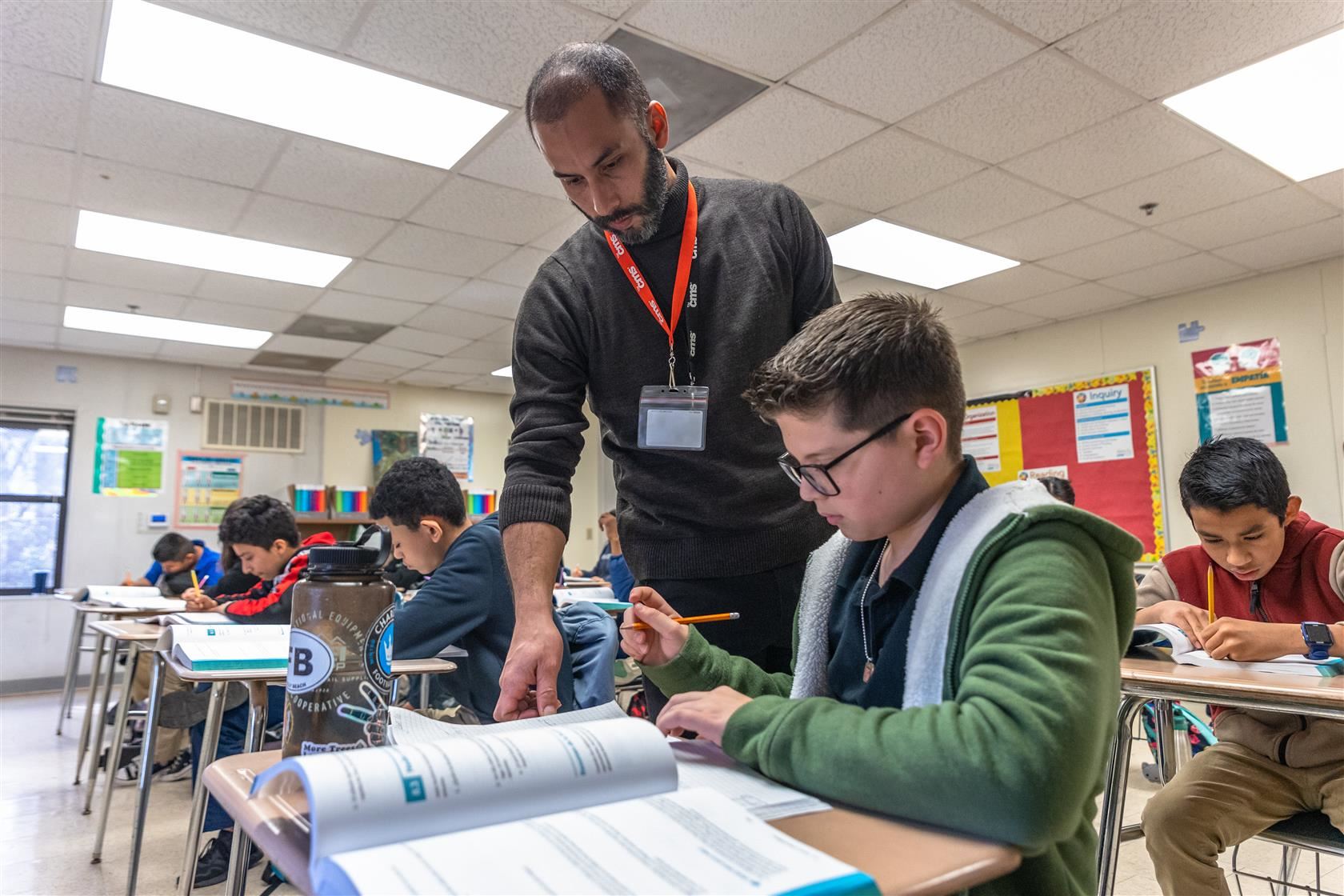 Goal 3 - Math 1 | Image of student working at their desk with guidance from instructor